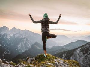 Frau beim Yoga auf einem Berggipfel