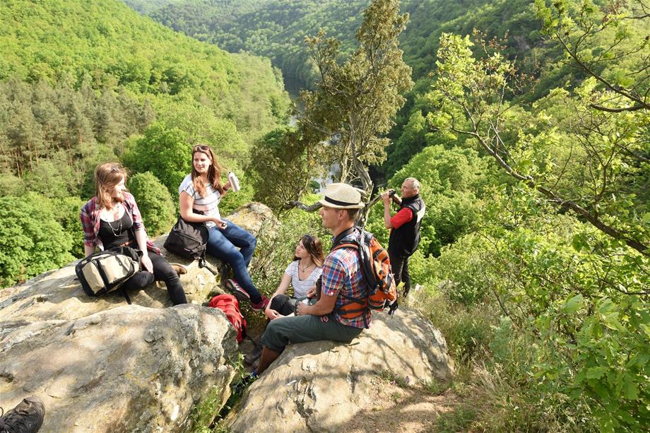 4 people are sitting on a rock which is located about 100 metres above the river Thaya