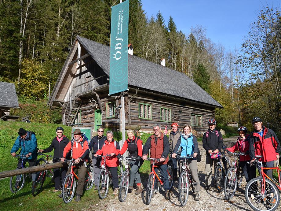 12 biker are standing in front of a wooden hut